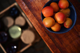 焦点成熟的即食杏子陶瓷碗木表格模糊的盒子小时罐子地板上