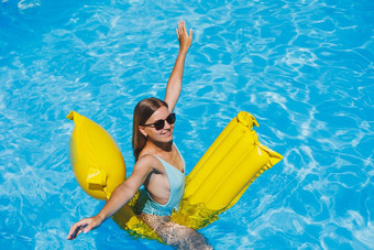 夏天生活方式肖像美丽的女人太阳镜浮动充气床垫户外游泳池夏天假期热带岛