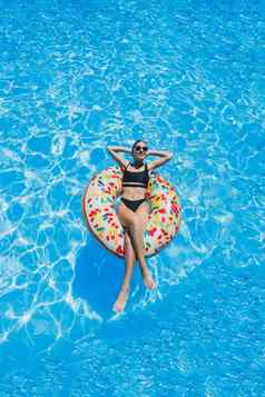 美丽的女人太阳镜池浮点数充气游泳环黑色的泳衣夏天照片游泳摄影夏天女人照片