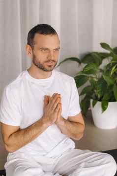 男人。白色运动服装瑜伽健身房间概念健康的生活方式