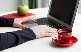 男人。手移动PC键盘笔记本绿色苹果红色的杯咖啡白色表格