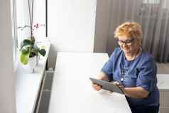 远程医疗概念女人平板电脑在线咨询医生生活房间