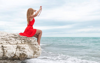 美丽的女人红色的衣服<strong>白色岩石</strong>海夏天