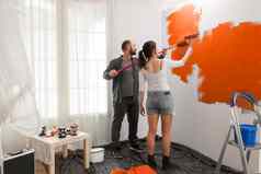 年轻的家庭绘画墙橙色油漆