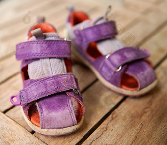 前视图紫色的婴儿鞋子表格首页女孩鞋子象征着生活开始怀孕小时尚的时尚凉鞋好玩的孩子桌子上