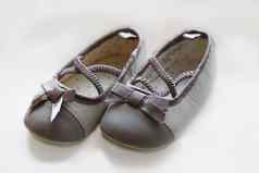 可爱的婴儿鞋子白色背景期待到来女孩准备好了玩衣服灰色芭蕾舞女演员泵可爱的弓新生儿靴怀孕公告