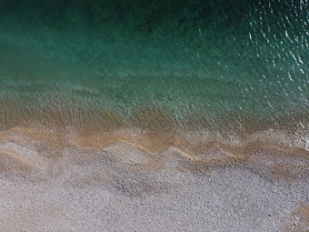 空中视图Azure海粉红色的鹅卵石海滩小波玻璃清晰的水表面运动模糊夏天海洋海海滩背景假期假期旅行概念