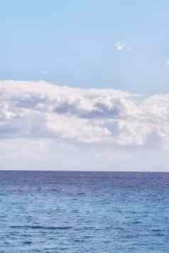 多云的蓝色的天空和平平静海洋分离美丽的地平线复制空间深蓝色的水下面Cloudscape天际线潮汐电流波宽开放海