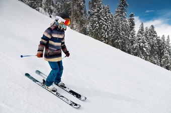 滑雪条纹夹克坡滑雪度假胜地活跃的冬天娱乐滑雪阳光明媚的一天女人滑雪