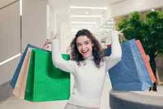 快乐满意年轻的女人女孩购物购物购物中心显示购买彩色的纸袋喜乐笑着说
