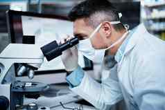 工作临床试验成熟的男人。显微镜进行制药研究