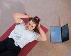 胖乎乎的年轻的女人看在线健身教训移动PC距离体育培训