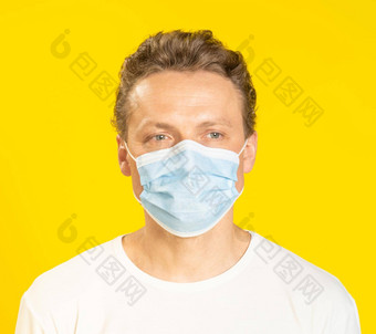 伤心脸年轻的男人。穿医疗面具脸生病的年轻的男人。脸面具穿白色t恤孤立的黄色的背景生病的高加索人男人。保护脸面具
