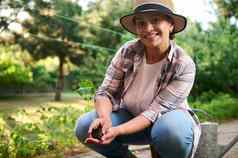 漂亮的女人农学家加德纳持有黄瓜幼苗准备好了种植受精开放地面黑色的土壤