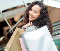 肖像美丽的混合比赛女人站自动扶梯购物购物中心年轻的拉美裔女人携带袋支出钱销售好零售治疗