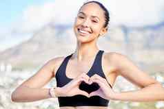 肖像自信年轻的混合比赛女人手势心形状手锻炼在户外快乐女运动员有爱心的身体常规的培训锻炼运行支持健康的活跃的生活方式