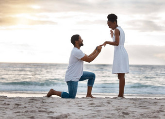 的男朋友女朋友结婚站海滩非洲美国男人。提出女朋友海滨年轻的快乐夫妇订婚了假期