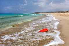 明亮的红色的塑料石油洗液体容器美丽的未遭破坏的海滩海洋塑料乱扔垃圾概念karpazz北部塞浦路斯
