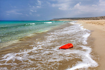 明亮的红色的塑料石油洗液体容器美丽的未遭破坏的海滩<strong>海洋</strong>塑料乱扔<strong>垃圾</strong>概念karpazz北部塞浦路斯