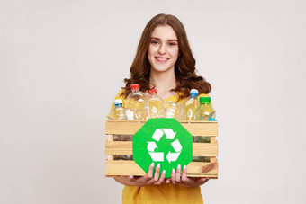 微笑积极的少年女孩棕色（的）头发持有盒子<strong>塑料</strong>瓶<strong>回收</strong>绿色象征排序垃圾储蓄生态