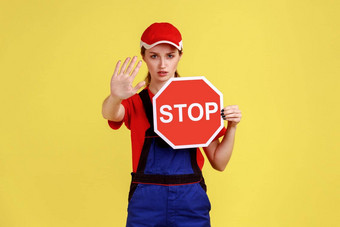 工人女人显示停止手势持有红色的停止路标志禁忌限制