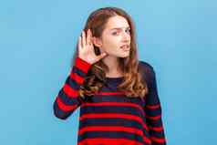 女人穿条纹毛衣持有手耳朵听小心翼翼地听力问题耳聋误解沟通