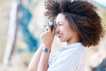 年轻的微笑混合比赛女人非洲式发型持有相机照片快乐拉美裔女人卷曲的头发采取图片充满激情的熟练的爱好摄影