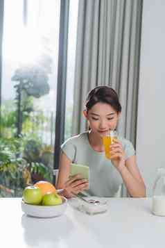 完美的早....快乐积极的女人吃早餐会说话的智能手机
