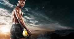 肖像美国黑人运动员海滩排球球员球天空背景适合年轻的男人。运动服装持有球