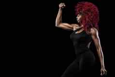 运动美丽的美国黑人模型女人运动服装使健身锻炼黑色的背景保持适合