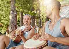 使音乐森林年轻的但坐着玩音乐的仪器野营旅行森林