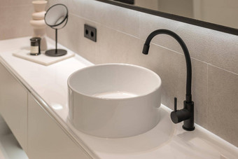 特写镜头现代黑色的水龙头白色轮水槽基座现代极简主义风格浴室