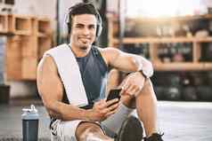 肖像快乐教练健身房强大的适合男人。听音乐锻炼强大的健美运动员采取打破锻炼类智能手机音乐需要培训
