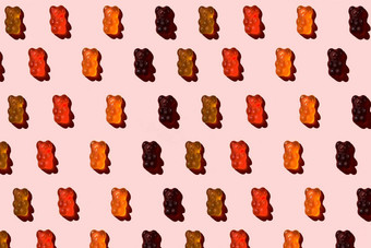 模式使色彩斑斓的果冻熊粉红色的背景平躺最小的概念