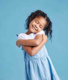 可爱的可爱的女孩快乐拥抱拥抱可爱的孩子积极的自尊蓝色的工作室背景