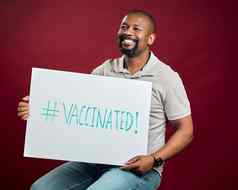 非洲美国科维德接种疫苗男人。显示持有海报微笑黑色的男人。孤立的红色的工作室背景Copyspace快乐模型标志促进电晕疫苗激励