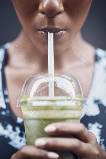 特写镜头活跃的女人喝健康的绿色排毒奶昔锻炼在户外女运动员喝着新鲜的水果汁稻草塑料杯净化提供能源培训有益健康的喝维生素<strong>营养物质</strong>