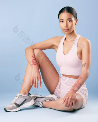 混合比赛健身女人坐着打破锻炼工作室蓝色的背景年轻的拉美裔女运动员休息集锻炼例程健康健身