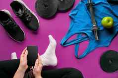 年轻的女人移动电话体育运动设备颜色背景平躺前视图健身概念