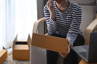 年轻的女人确认订单客户市场电话准备包裹盒子交付首页办公室