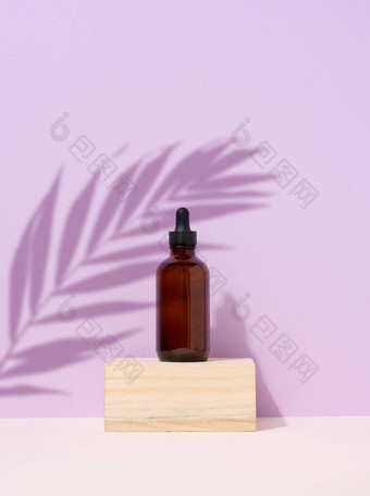 棕色（的）玻璃瓶吸管紫色的背景棕榈叶影子