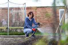 快乐女人浇水植物花园房子