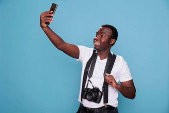 快乐的摄影师采取自拍照片智能手机