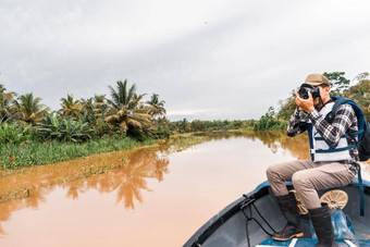 拉丁美洲人男人。航行船泥泞的河采取图片