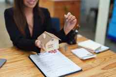 亚洲女银行员工将房子键客户端签署合同文书工作