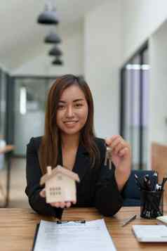 肖像亚洲女银行员工将房子键客户端签署合同文书工作