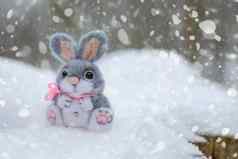 有趣的兔子雪圣诞节复活节概念玩具灰色的毛坐在雪堆背景森林下降雪明信片可打印的的地方文本