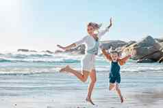 肖像无忧无虑的微笑妈妈。兴奋女儿跳快乐海滩快乐精力充沛的父好玩的兴奋孩子享受阳光明媚的夏天假期海滨快乐的有趣的家庭