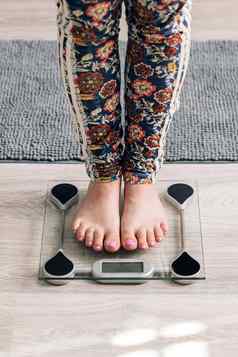 特写镜头光着脚女人数字尺度检查重量女脚一步地板上尺度概念节食失去重量健康的生活方式