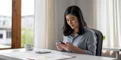 业务亚洲女人移动电话检查电子邮件社会媒体互联网会计金融概念